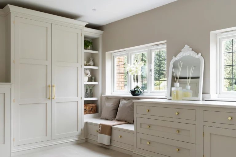 Cushioned window seat with open shelving and drawers, hand-painted in Little Greene ‘Joanna’, finished with brushed gold hardware