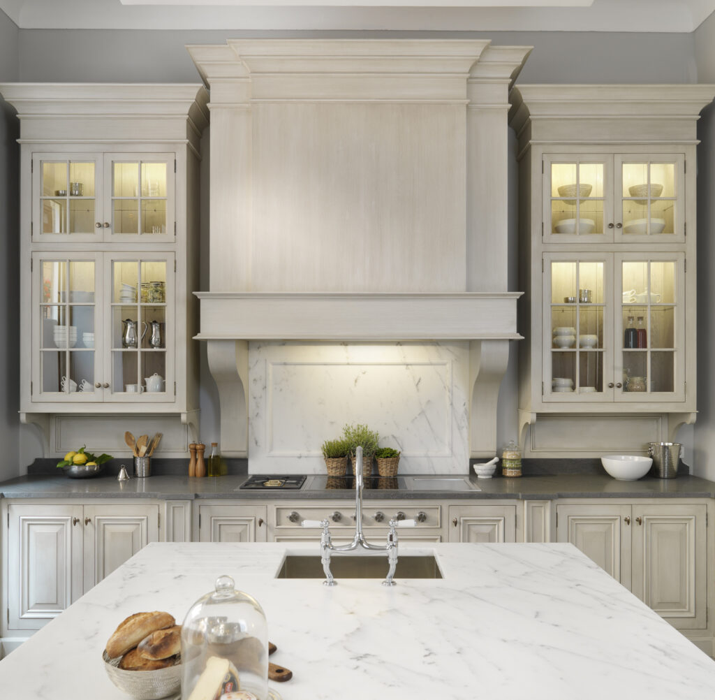 Hand-painted cabinetry with moulded canopy, illuminated glass cabinets and a Carrara marble splashback and island worktop