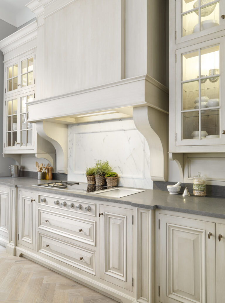 Hand-painted kitchen cabinetry with a Carrara marble splashback, panelled hood and illuminated glass display cabinets