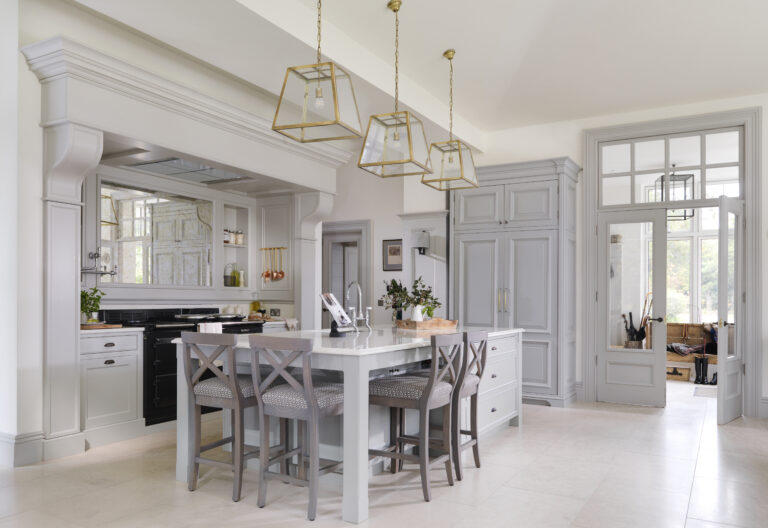 Bespoke kitchen with overmantel Aga, mirrored backsplash, large island, bar stools and brass pendant lights