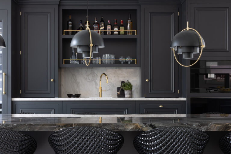 Dark cabinetry with open drinks shelving, brass fittings and gold tap, pendant lights above the XTONE Orobico Dark island