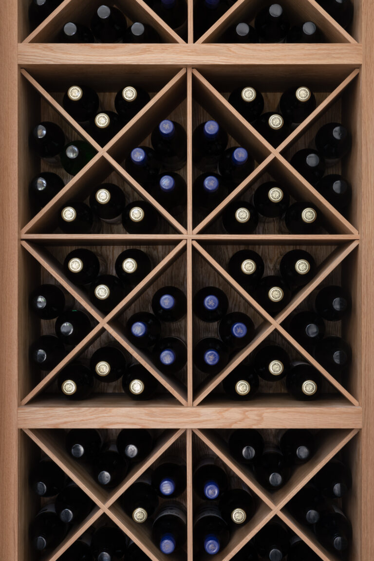 Diamond-shaped timber wine racking holds rows of bottles, forming part of the integrated home bar display