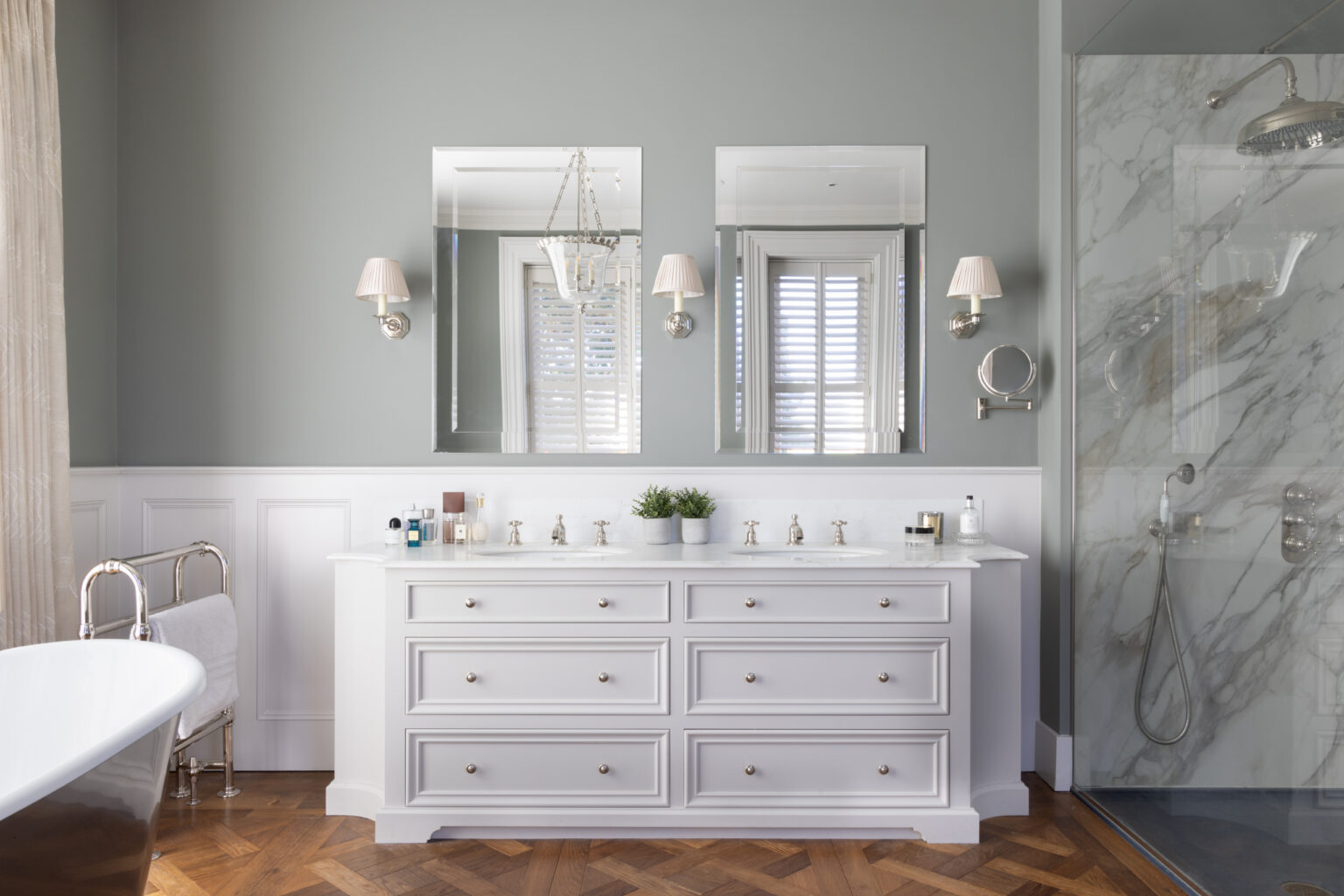 Master bathroom with a bespoke double vanity unit, twin mirrors, freestanding bath and separate stone shower enclosure