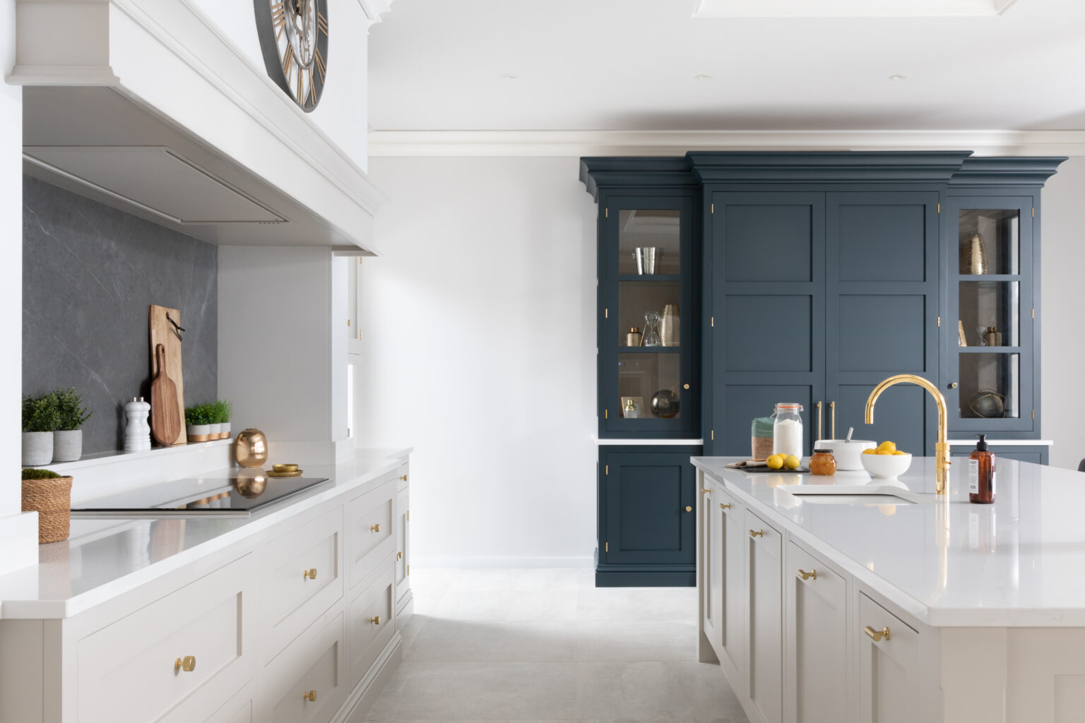 Kitchen with Cornforth White cabinetry, a Hague Blue dresser wall, gold tap and brass handles throughout