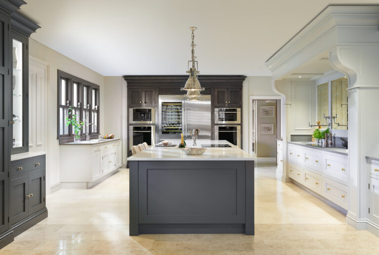 Large kitchen with a Down Pipe island, Caesarstone worktop, integrated fridge and ovens, and a polished pendant light above