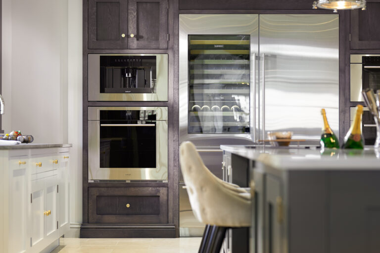 Chocolate Oak cabinetry houses integrated ovens, a coffee machine and a wine fridge beside the island