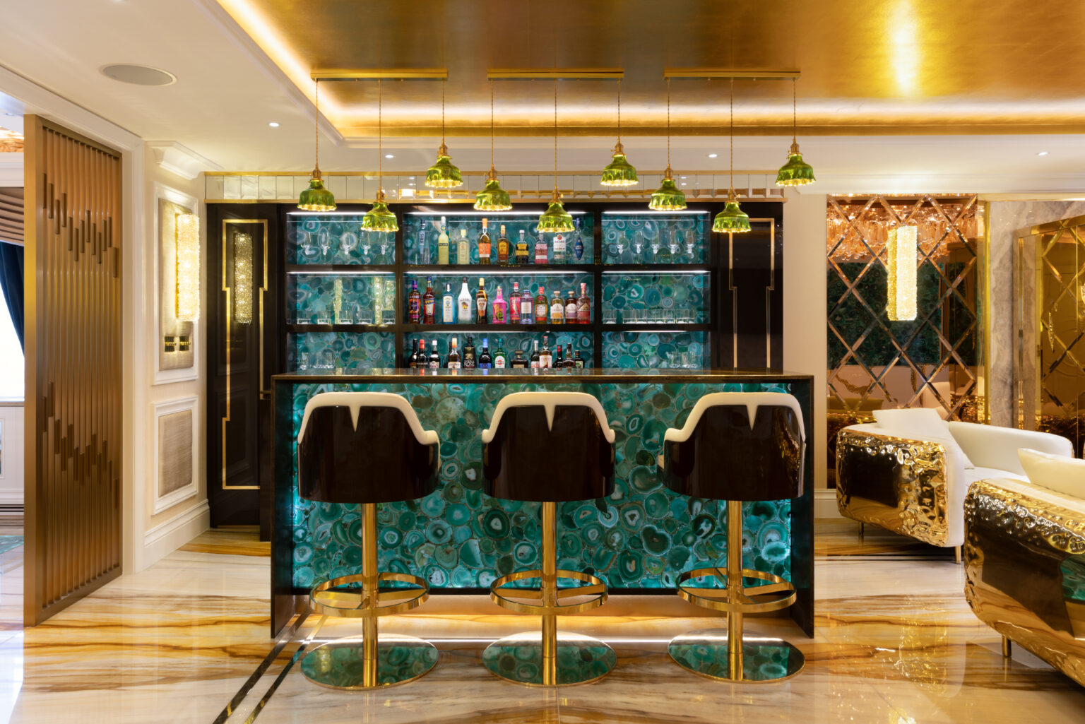 Finished penthouse bar with backlit green agate front and back panels, leather bar stools on gold bases and green glass pendants