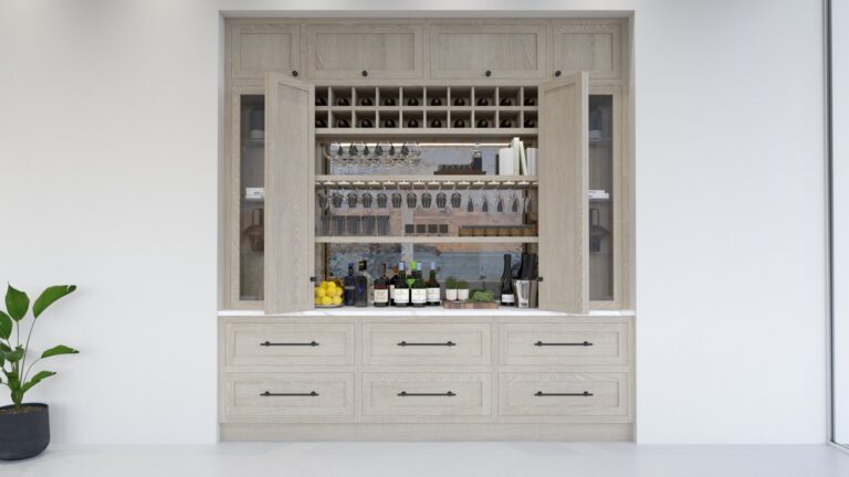 Light oak hidden bar cabinet opened to reveal wine racks, hanging glasses, bottles and a stone shelf