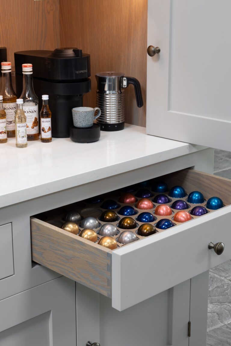 Coffee station with a fitted capsule drawer, Nespresso machine, milk frother and syrup bottles on the worktop