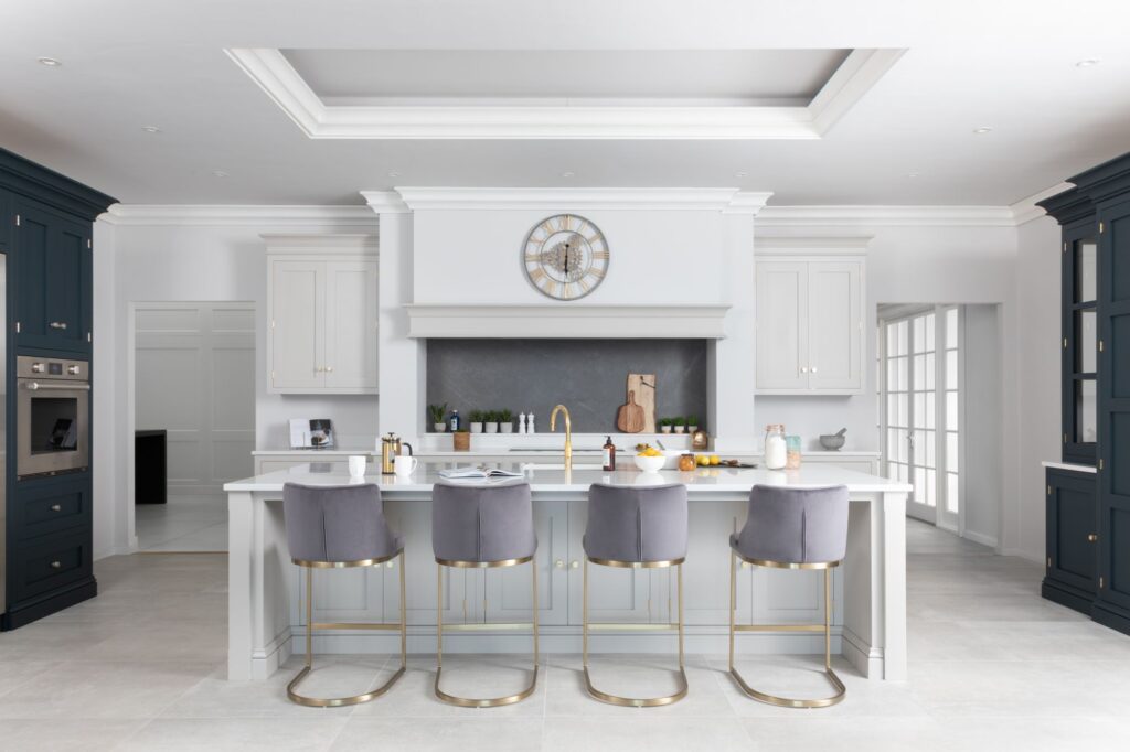 New England painted kitchen display with a canopy, island and navy tall cabinets in the Andrew Ryan Altrincham showroom