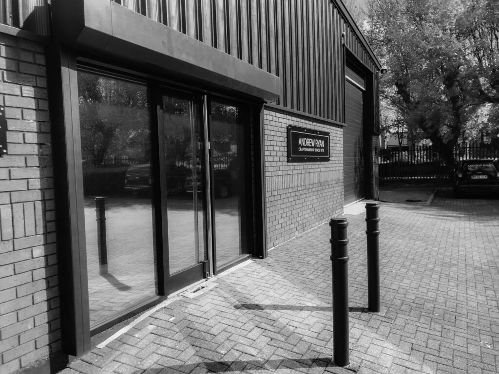 The glass-door entrance and black Andrew Ryan sign at the Altrincham showroom on Stag Estate