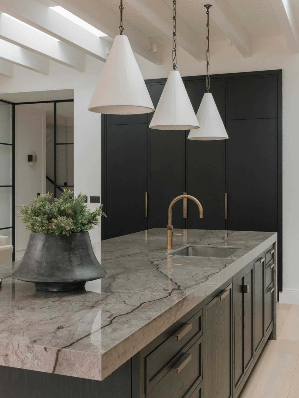70 mm Astana Grey stone island worktop with a brass tap and undermount sink, black-stained oak drawers below